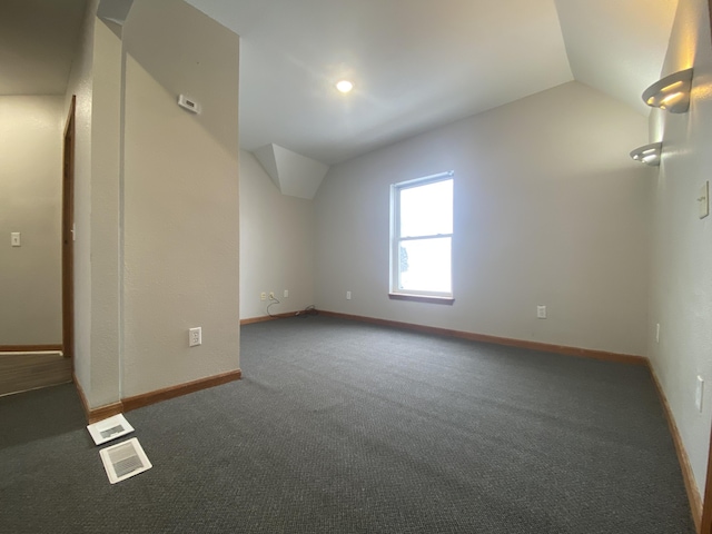 bonus room with lofted ceiling and dark carpet