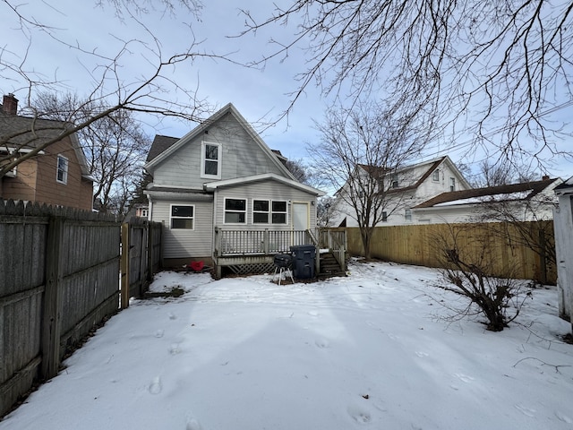 snow covered back of property featuring a deck