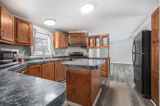 kitchen with sink, dark hardwood / wood-style flooring, a center island, stainless steel appliances, and crown molding