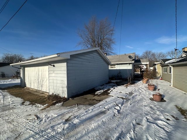 snow covered property with a garage