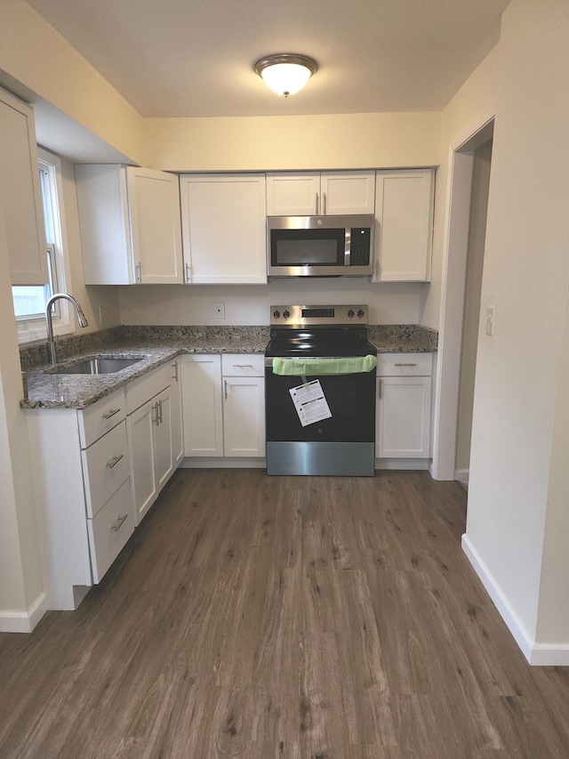 kitchen with sink, dark wood-type flooring, white cabinets, and appliances with stainless steel finishes