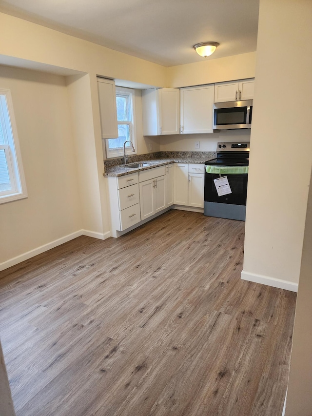 kitchen featuring white cabinetry, sink, light hardwood / wood-style flooring, and stainless steel appliances