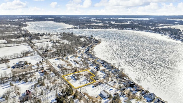 snowy aerial view with a water view