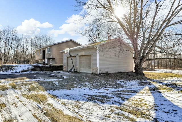 view of snow covered exterior featuring a garage