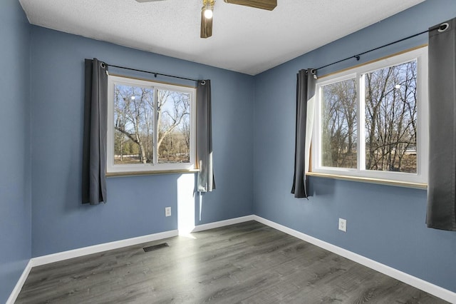 unfurnished room featuring ceiling fan, dark hardwood / wood-style floors, and a textured ceiling