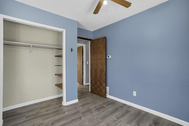 unfurnished bedroom with hardwood / wood-style floors, ceiling fan, and a closet