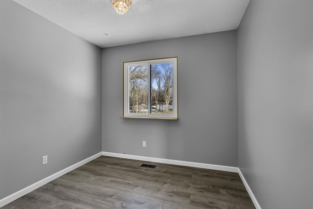 unfurnished room featuring wood-type flooring and a textured ceiling