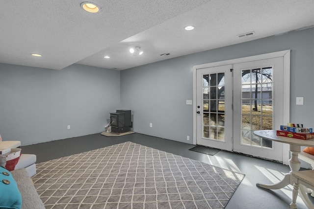 interior space with a textured ceiling and a wood stove