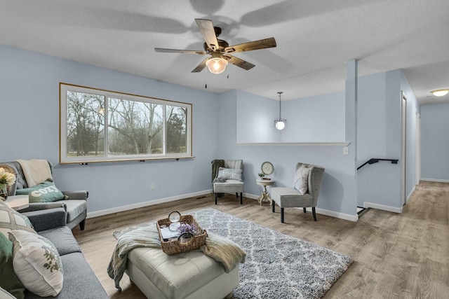 living area with ceiling fan and light hardwood / wood-style flooring