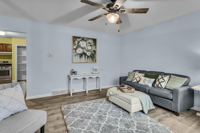 living room with hardwood / wood-style flooring and ceiling fan