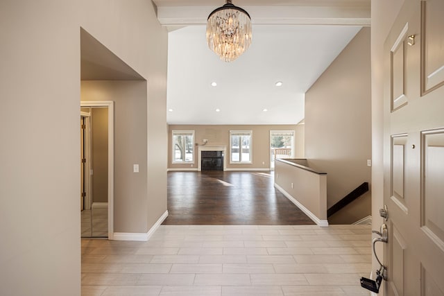 entrance foyer with an inviting chandelier, high vaulted ceiling, and light hardwood / wood-style floors