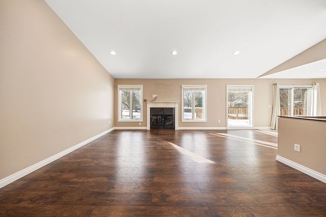 unfurnished living room featuring a premium fireplace, lofted ceiling, and dark hardwood / wood-style flooring