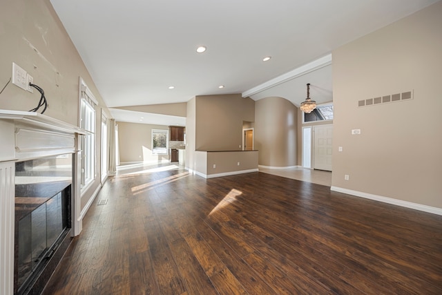 unfurnished living room featuring dark hardwood / wood-style flooring and high vaulted ceiling