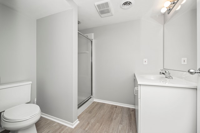 bathroom with vanity, hardwood / wood-style floors, an enclosed shower, and toilet