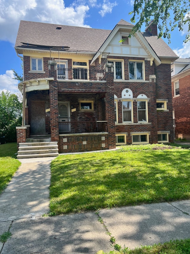 view of front of home featuring a front lawn and a balcony