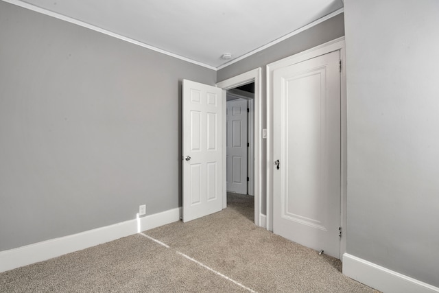 unfurnished bedroom featuring ornamental molding and carpet flooring