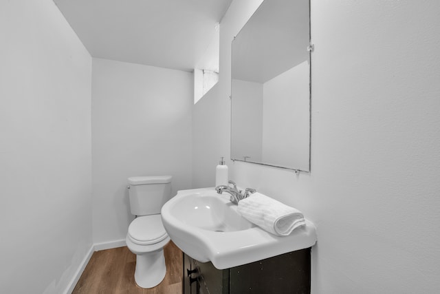 bathroom featuring hardwood / wood-style flooring and toilet