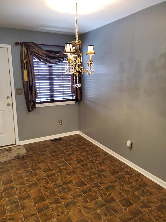 unfurnished dining area with an inviting chandelier