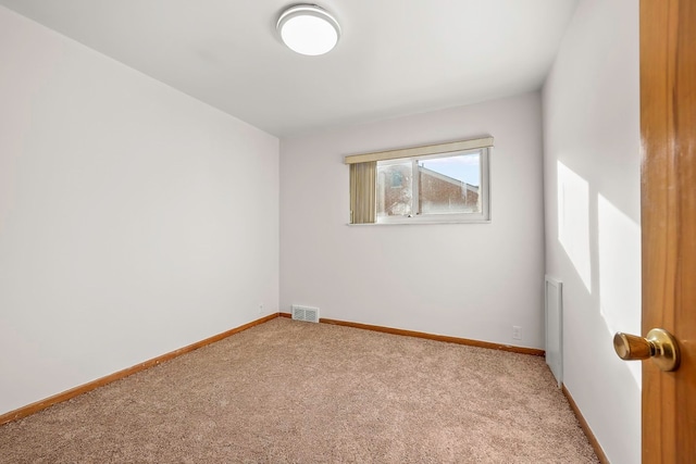 carpeted spare room featuring visible vents and baseboards