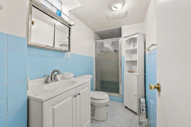 full bathroom featuring tile patterned flooring, visible vents, a stall shower, and tile walls