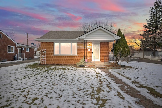 bungalow-style house with brick siding and a shingled roof