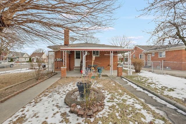 bungalow with a gate, fence, brick siding, and a chimney