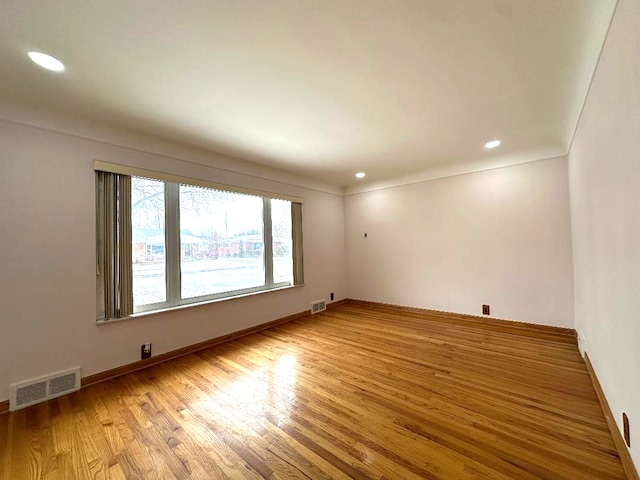 unfurnished room with light wood finished floors, visible vents, and recessed lighting