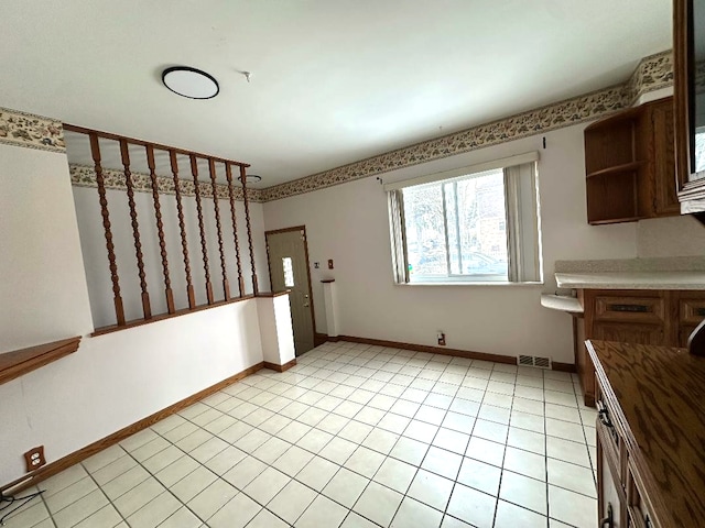 interior space with light tile patterned floors, visible vents, and baseboards