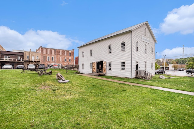 rear view of property featuring a lawn