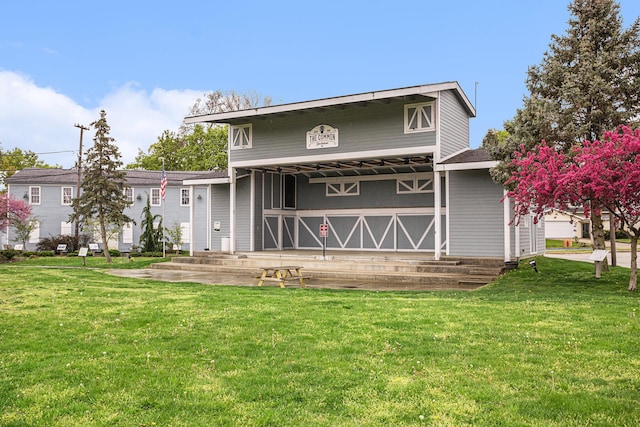 rear view of property featuring a lawn