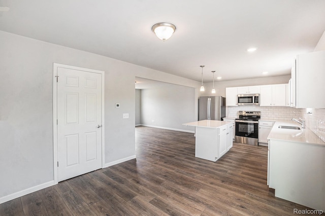 730 Natalia Dr, Davison, MI 48423 - kitchen with stainless steel appliances, a center island, dark wood finished floors, white cabinetry, and backsplash
