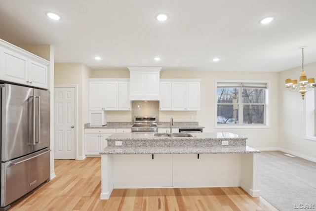 kitchen with white cabinetry, stainless steel appliances, sink, and pendant lighting