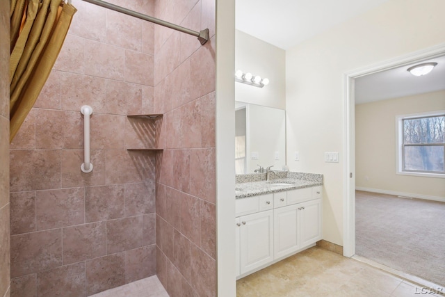 bathroom featuring tile patterned flooring, vanity, and walk in shower