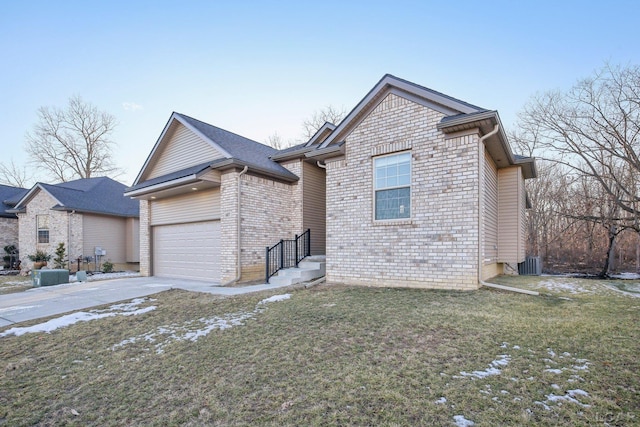 view of front of property with a garage, central AC unit, and a front lawn