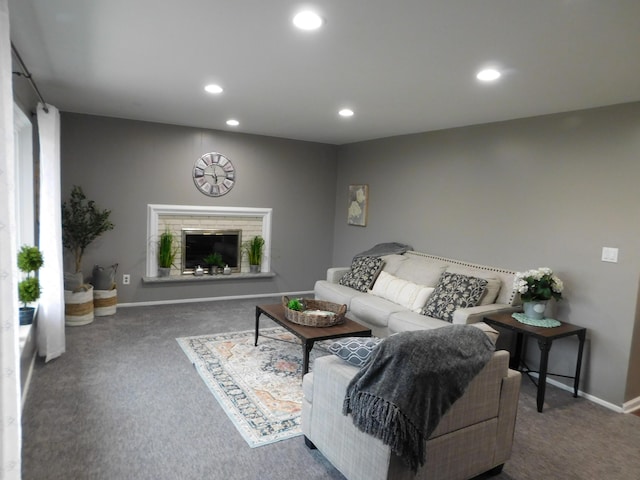 living room featuring a brick fireplace and dark colored carpet