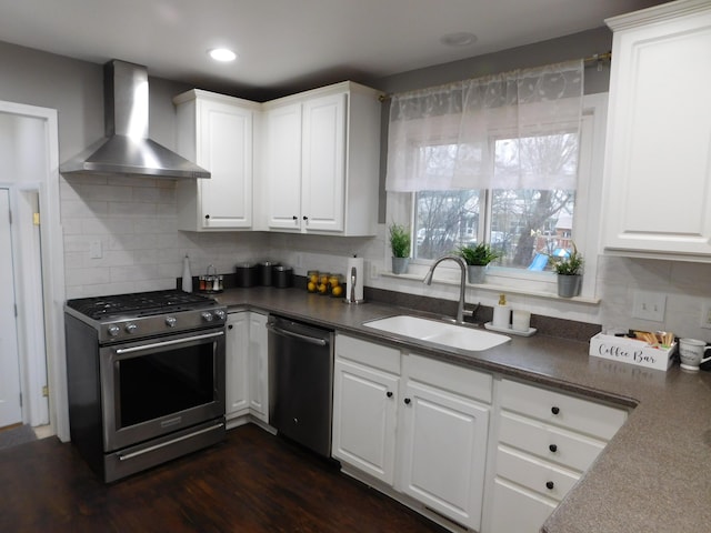 kitchen with sink, white cabinetry, backsplash, stainless steel appliances, and wall chimney exhaust hood