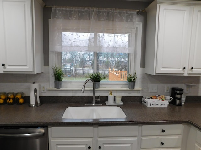 kitchen featuring dishwasher, sink, white cabinets, and decorative backsplash