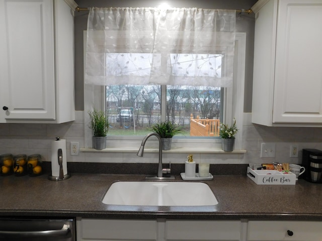 kitchen featuring tasteful backsplash, sink, dishwasher, and white cabinets