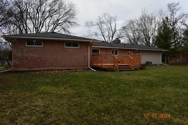 rear view of house with a lawn and a deck