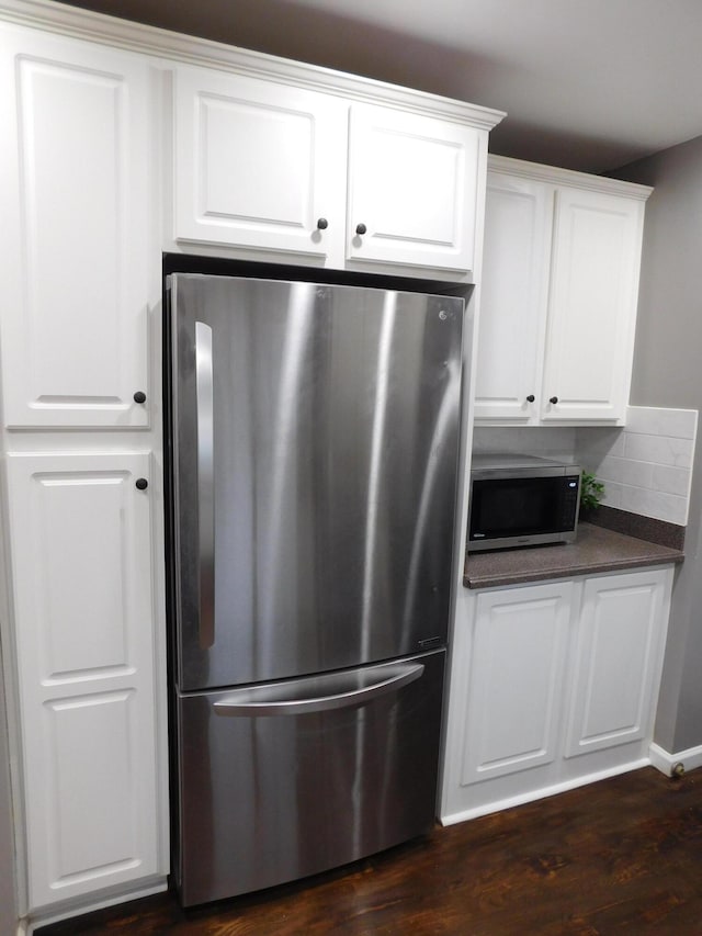 kitchen featuring backsplash, dark wood-type flooring, stainless steel appliances, and white cabinets