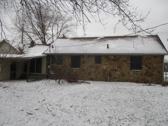 view of snow covered back of property