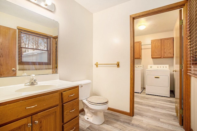 bathroom with vanity, wood-type flooring, toilet, and washing machine and clothes dryer