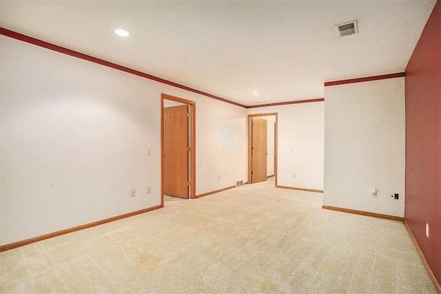 empty room featuring light colored carpet and ornamental molding