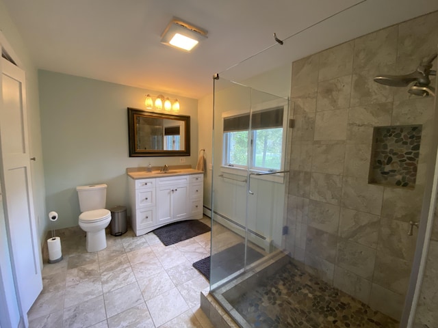 bathroom with tile patterned flooring, vanity, an enclosed shower, baseboard heating, and toilet