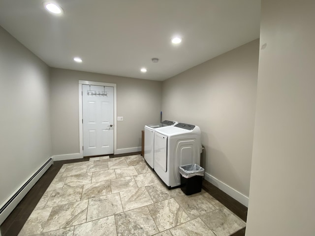 clothes washing area featuring washing machine and dryer and a baseboard heating unit