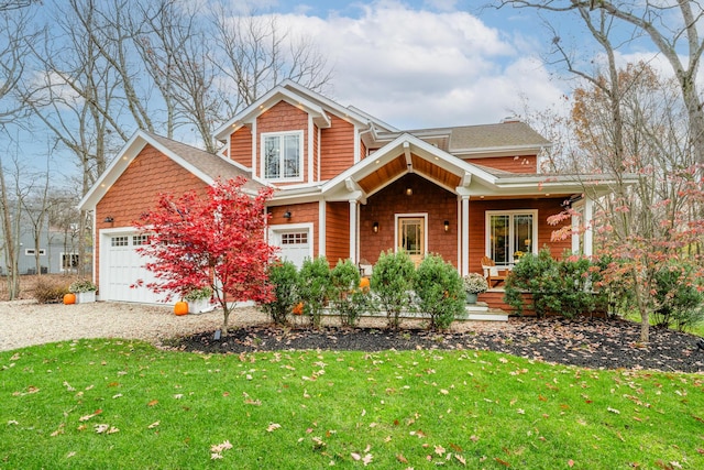 view of front facade featuring a porch, a garage, and a front yard