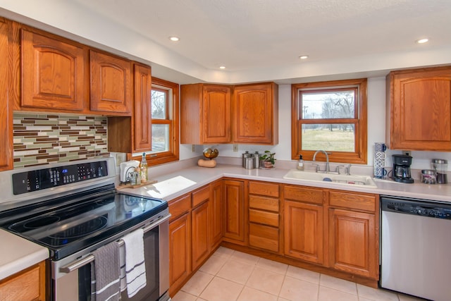 kitchen with tasteful backsplash, appliances with stainless steel finishes, sink, and light tile patterned floors