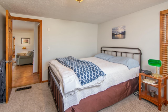 carpeted bedroom featuring a textured ceiling