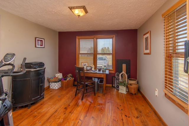 office area featuring light hardwood / wood-style floors and a textured ceiling