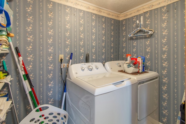 washroom featuring crown molding, washing machine and dryer, and a textured ceiling